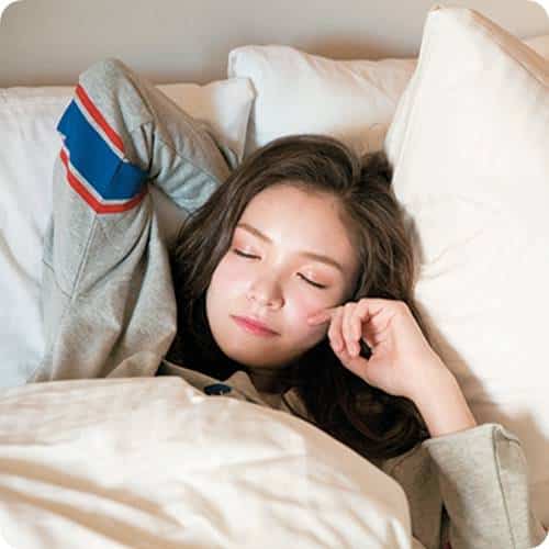 a woman lying in bed with her eyes closed