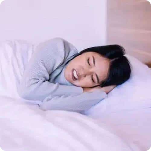 a woman lying in bed with her eyes closed